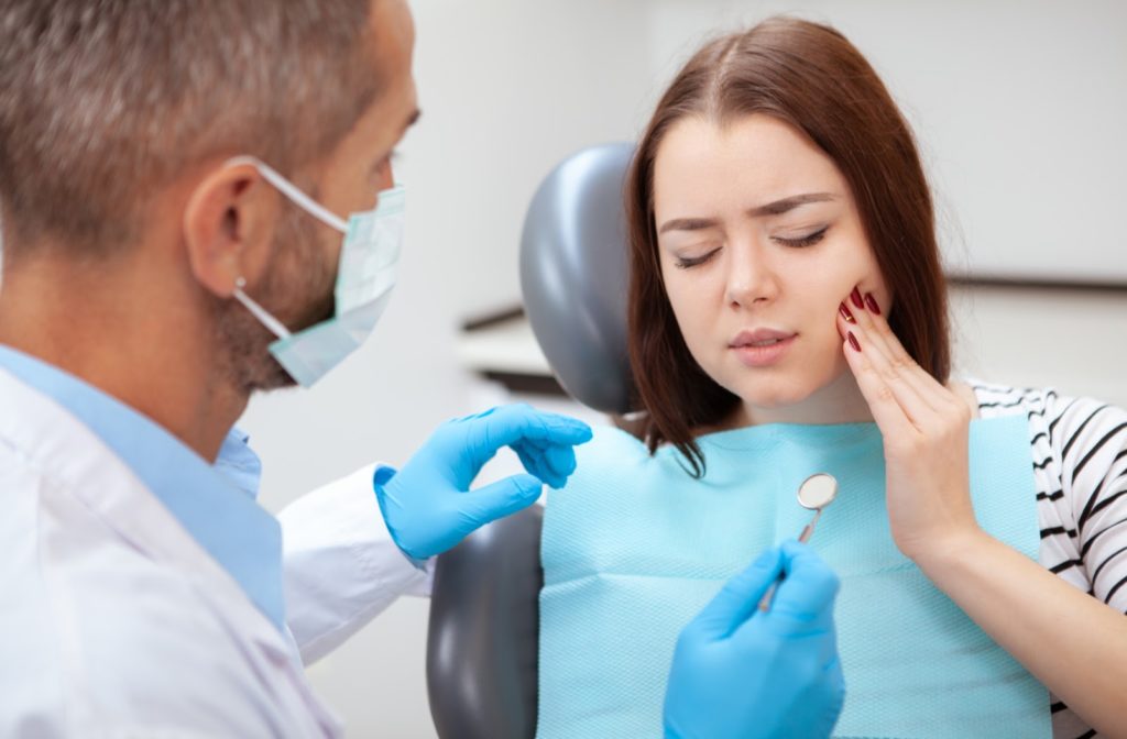 Woman with a painful toothache at the dentist seeking immediate care