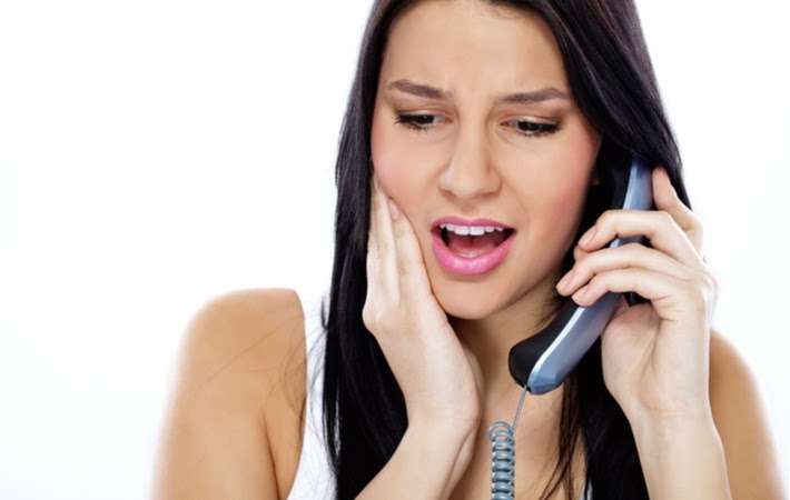 Woman on the phone with her dentist because she lost a dental crown