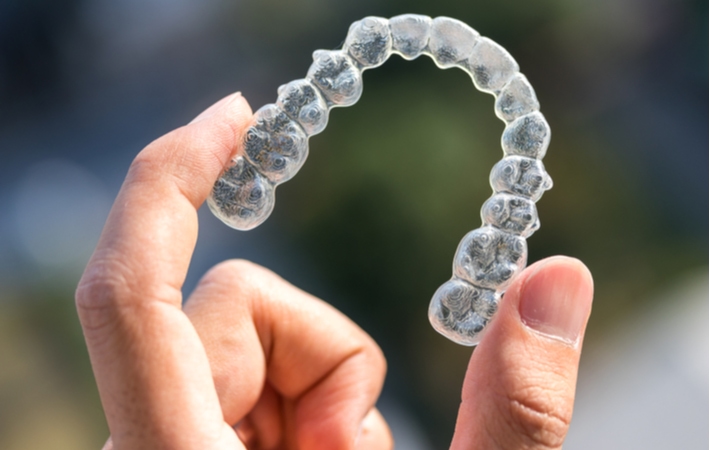 A person holding up an Invisalign
