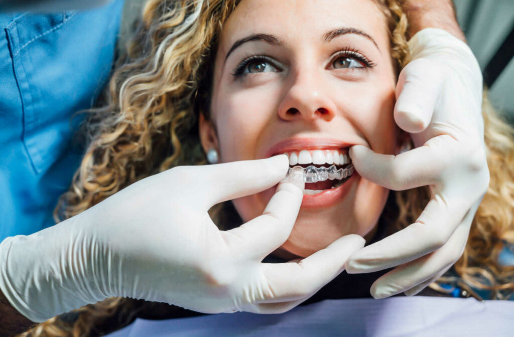 A woman at the dentist having her Invisalign clear aligners put in