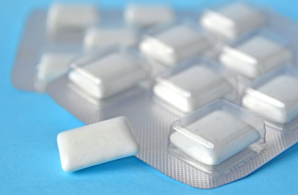 A packet of sugar free gum sitting on a blue surface, as a alternative to chew over chewing ice.